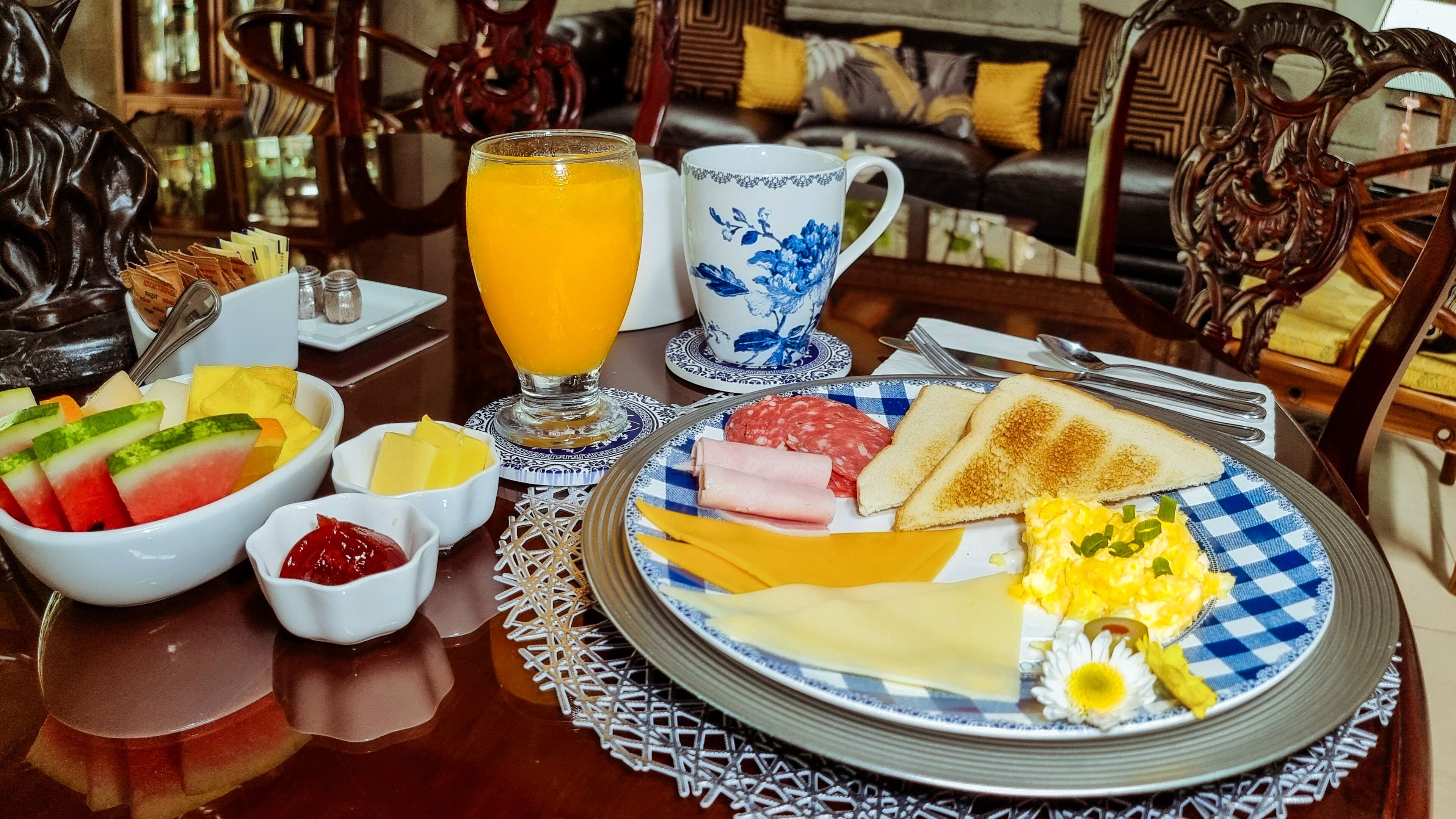 A breakfast table with a variety of food items, including toast, eggs, and fruit.
