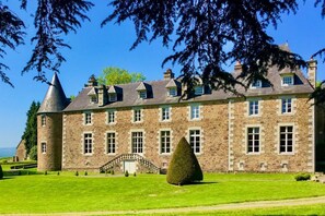 A large stone building with multiple windows, a central entrance, and a well-maintained lawn. - Chateau Quatre Saisons (Domjean)