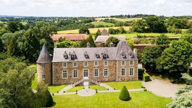 A large stone building with multiple towers and a central courtyard. - Chateau Quatre Saisons (Domjean)