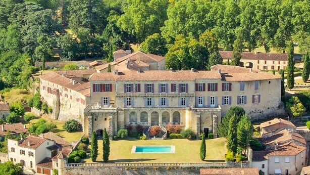 Un grand bâtiment historique doté d’une cour intérieure et d’une piscine.