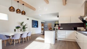 A modern kitchen with white cabinets, a central island, and pendant lighting.