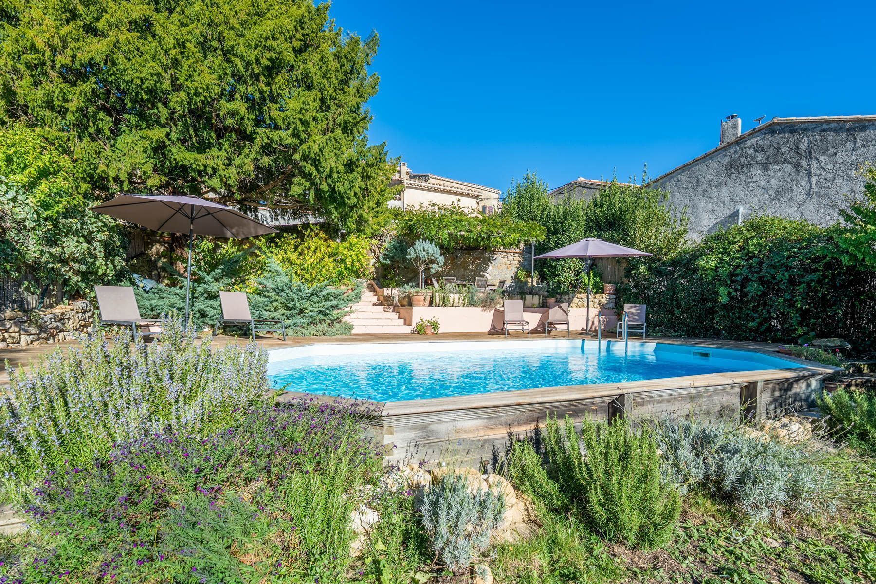 A swimming pool surrounded by lush greenery and outdoor seating areas.