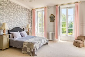 A bedroom with a bed, nightstands, a chair, and large windows with curtains. - Chateau Des Temps - Ten Bedroom Castle, Sleeps 20 (Pleurs)