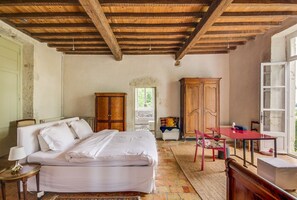 A bedroom with a bed, a wooden wardrobe, a table with chairs, and a window. - La Maison Des Moines (Loubès-Bernac)