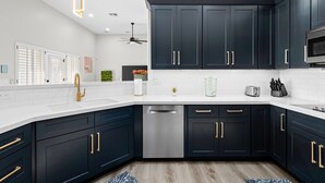 A modern kitchen with dark cabinets, stainless steel appliances, and a white countertop. - BILTMORE BLISS→Rooftop w/ Mountain/City View, Pool (Phoenix)