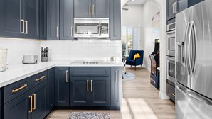 A modern kitchen with dark cabinets, stainless steel appliances, and a white countertop. - BILTMORE BLISS→Rooftop w/ Mountain/City View, Pool (Phoenix)