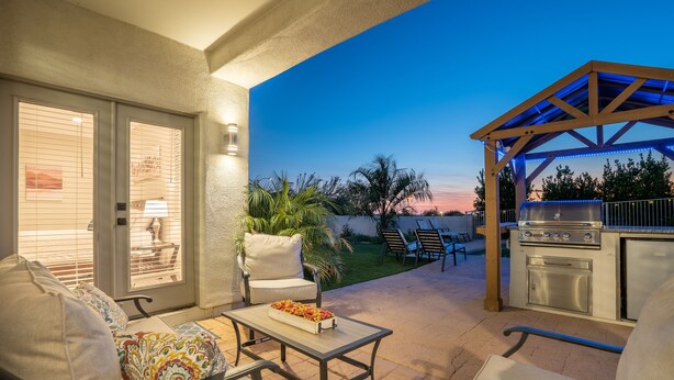 An outdoor patio with a grill, seating, and a view of the backyard. - BILTMORE BLISS→Rooftop w/ Mountain/City View, Pool (Phoenix)