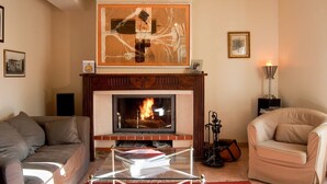 A living room with a fireplace, a sofa, a chair, and a coffee table. - Cottage Des Cathares (Plaigne)