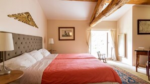 A bedroom with two beds, a wooden ceiling, a framed picture on the wall, and a window with curtains. - Cottage Des Cathares (Plaigne)
