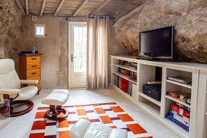 Une pièce comprenant une télévision, un bureau, une chaise et une bibliothèque.