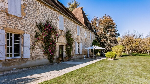 A stone building with a gravel driveway, a covered patio, and a well-maintained lawn. - Manoir 1731 - Six Bedroom Villa, Sleeps 12 (Carlux)