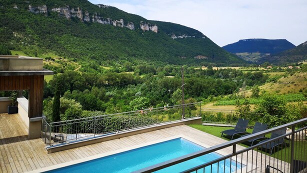 Ein Poolbereich mit Blick auf eine gebirgige Landschaft.