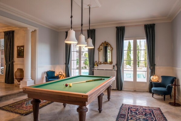 A pool table in a room with large windows, a mirror, and a blue armchair. - Chateau Grand Cru - Five Bedroom Castle, Sleeps 10 (Saint-Emilion)