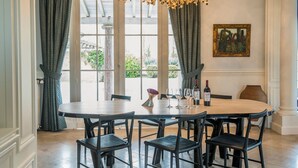 A dining area with a round table, six chairs, and a chandelier. - Chateau Grand Cru - Five Bedroom Castle, Sleeps 10 (Saint-Emilion)