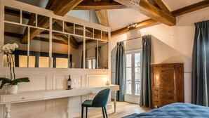 A bedroom with a large window, a wooden wardrobe, a desk with a chair, and a bed with a blue blanket. - Chateau Grand Cru - Five Bedroom Castle, Sleeps 10 (Saint-Emilion)