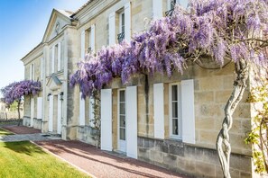 Un bâtiment historique doté d’une façade en pierre, de grandes fenêtres et d’une galerie couverte.