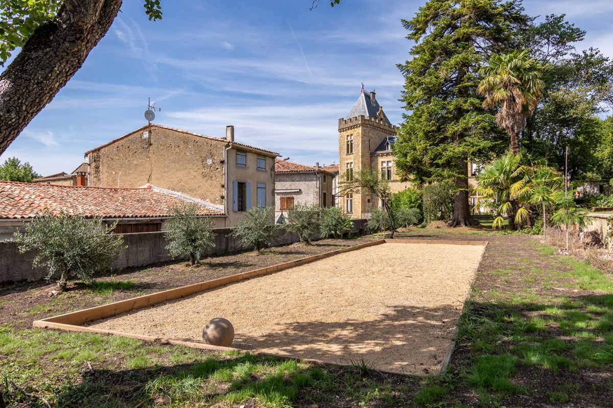 A courtyard with a tennis court, a tower, and surrounding buildings.