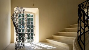A staircase with a wrought iron railing and a decorative metal gate at the top. - Chartreuse Des Roses (Pinsac)