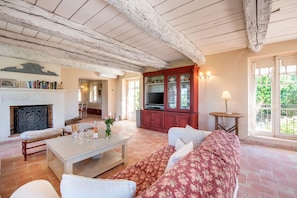 Een woonkamer met een open haard, een televisie en een bank.