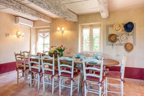 A dining area with a round table, chairs, and a wall-mounted hat rack.