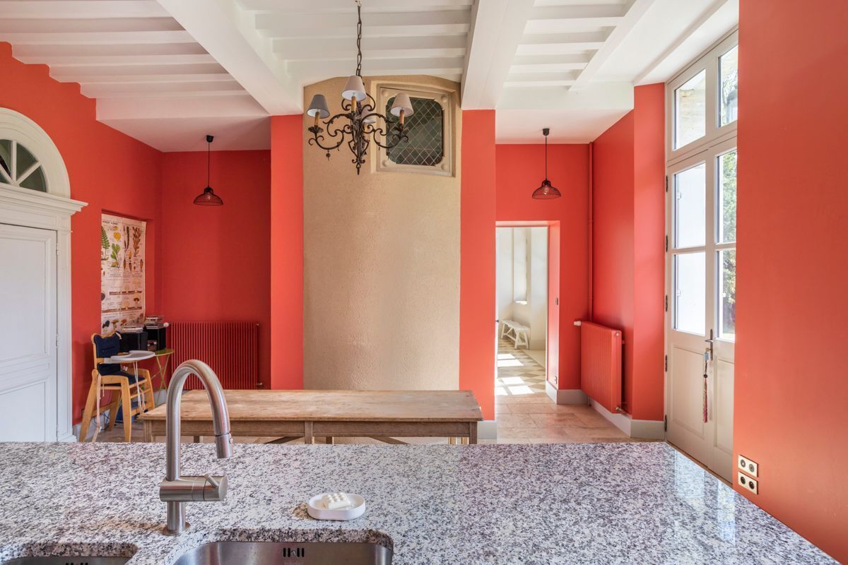 Una cocina con encimeras de granito, un lavamanos de acero inoxidable y una banca.