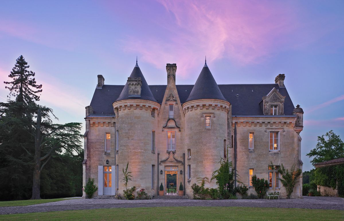 Un grand bâtiment en pierre, doté de nombreuses tours et d’une entrée centrale.