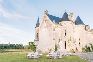 Un château doté de nombreuses tours et d’une cour intérieure avec des tables et des chaises.
