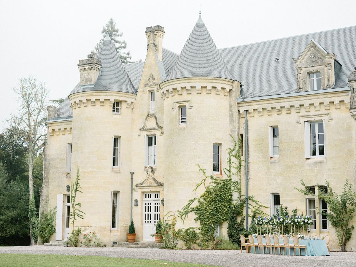 Un grand bâtiment historique doté de nombreuses tours et d’un jardin bien entretenu.