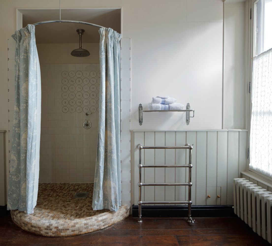 Une salle de bain avec une douche, un porte-serviettes et un radiateur.