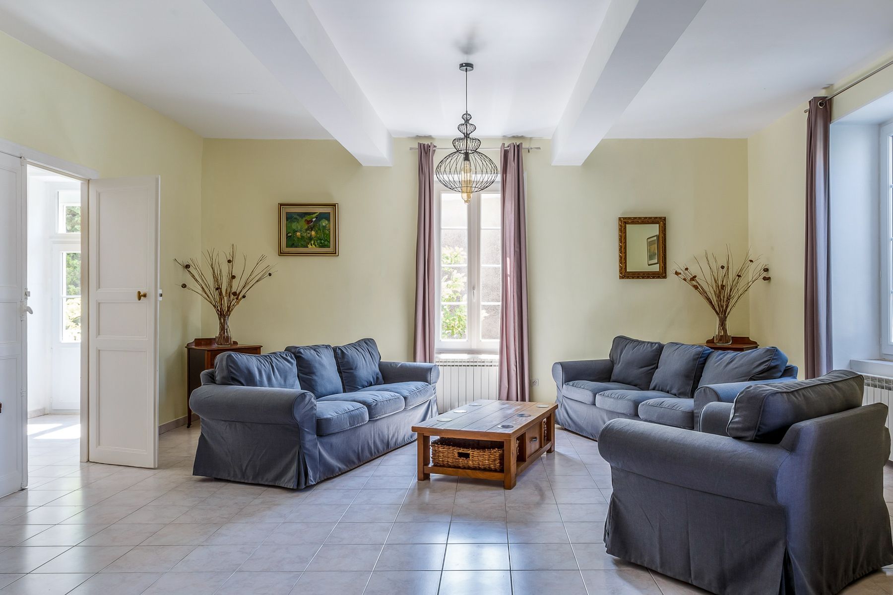 A living room with two sofas, a coffee table, and a chandelier.
