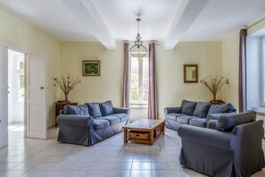 A living room with two sofas, a coffee table, and a chandelier. - Villa Du Midi - Four Bedroom Villa, Sleeps 8 (Cruzy)