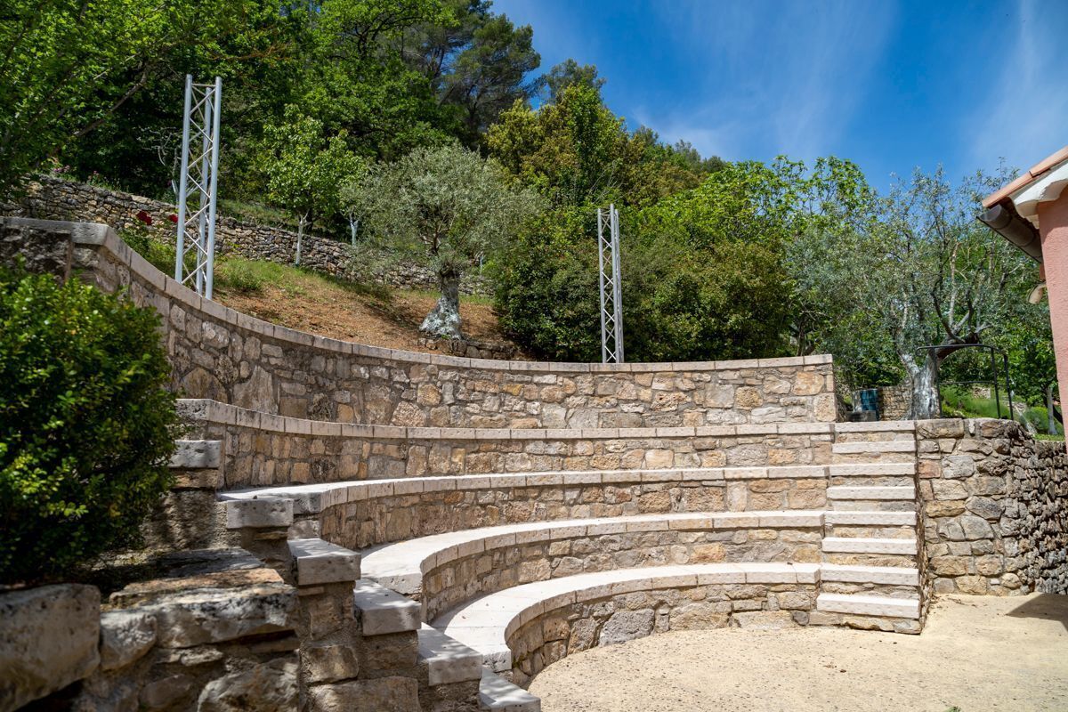 Ein Steine Amphitheater mit abgestuften Sitzreihen und Metallgeländern.