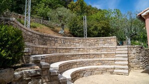 A stone amphitheater with tiered seating and metal railings.