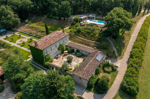 Una extensa propiedad con piscina, cancha de tenis y un jardín bien cuidado.