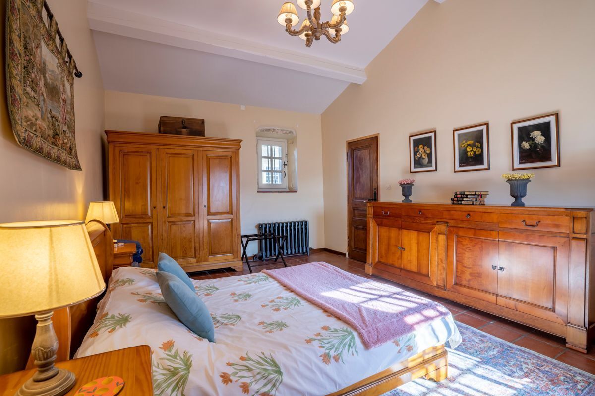 A bedroom with a bed, wooden wardrobe, and a radiator.
