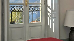 Una habitación con una puerta blanca que da a un balcón con vistas a la montaña.