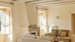 Una sala de estar con chimenea, un juego de sofás y una mesa de centro.