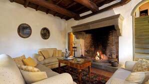 A cozy living room with a fireplace, sofas, and a coffee table. - Casa Poggio - Four Bedroom Villa, Sleeps 12 (Cassia)