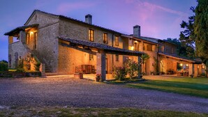 A stone building with a covered patio and a gravel driveway.