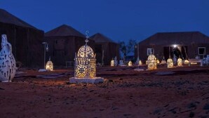 A desert landscape with multiple tents and illuminated lanterns. - Fabulous Desert Camp (Merzouga)