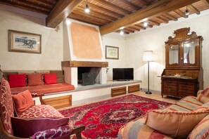 A cozy living room with a fireplace, sofa, and television.