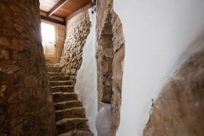 Eine Steintreppe mit einer weißen Wand an einer Seite und einer Holzzahl.