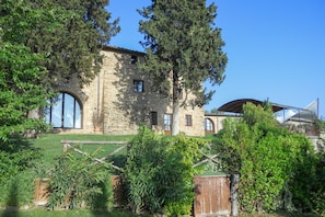 Un edificio de piedra con ventanas de arco y un espacio al aire libre techado.