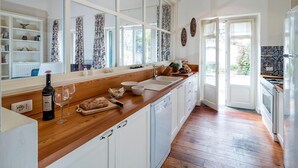 Une cuisine moderne avec des plans de travail en bois, des armoires blanches et une grande fenêtre.