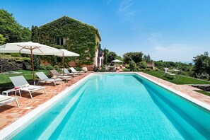 A rectangular swimming pool with clear blue water, surrounded by a wooden deck and white lounge chairs. - Dimora Ronzini - Four Bedroom Villa, Sleeps 6 (Trecastagni)