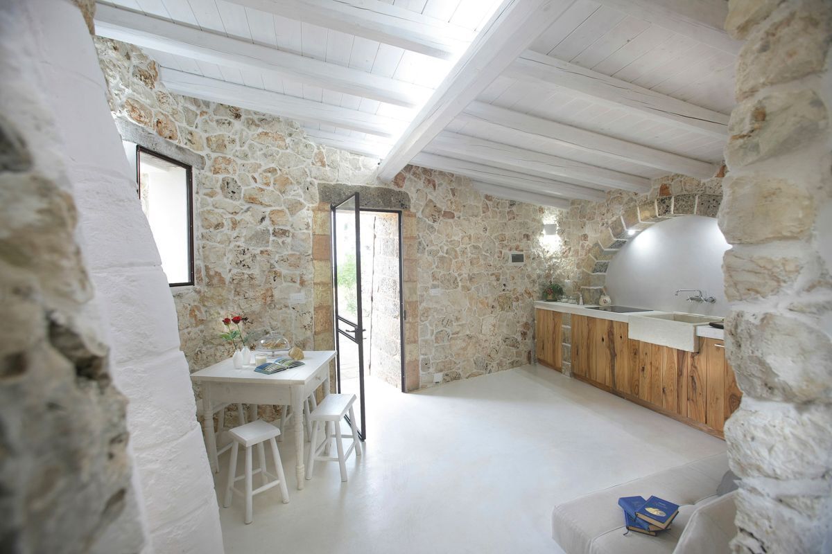 Un intérieur rustique en pierre, avec un comptoir en bois et un grand évier.