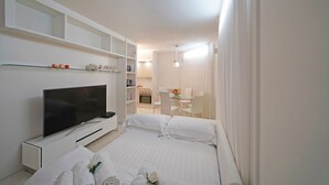 Una habitación de hotel con televisión, cama, escritorio y silla.