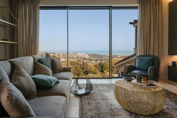 A modern living room with a large window offering a scenic view of the countryside.