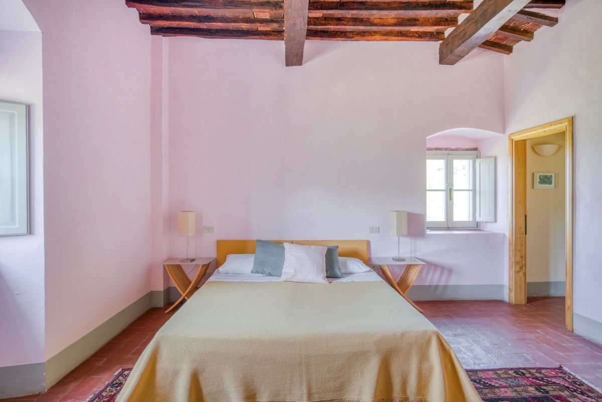 Una camera da letto con un letto con struttura in legno, un comodino con una lampada e una finestra vista panoramica.