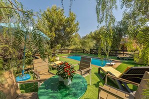 A backyard with a swimming pool, surrounded by lush greenery and a wooden deck. - Torre del Drago - Three Bedroom Villa, Sleeps 6 (Marina di Felloniche)